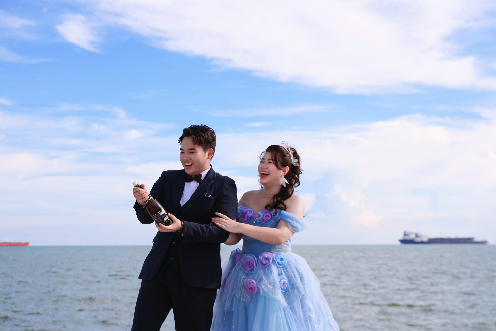 Anson and Jessy celebrating by the sea with champagne 海边庆祝